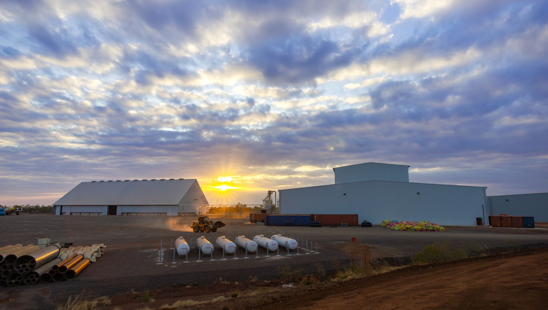 A red car with the hood up is parked on the side of the road.
