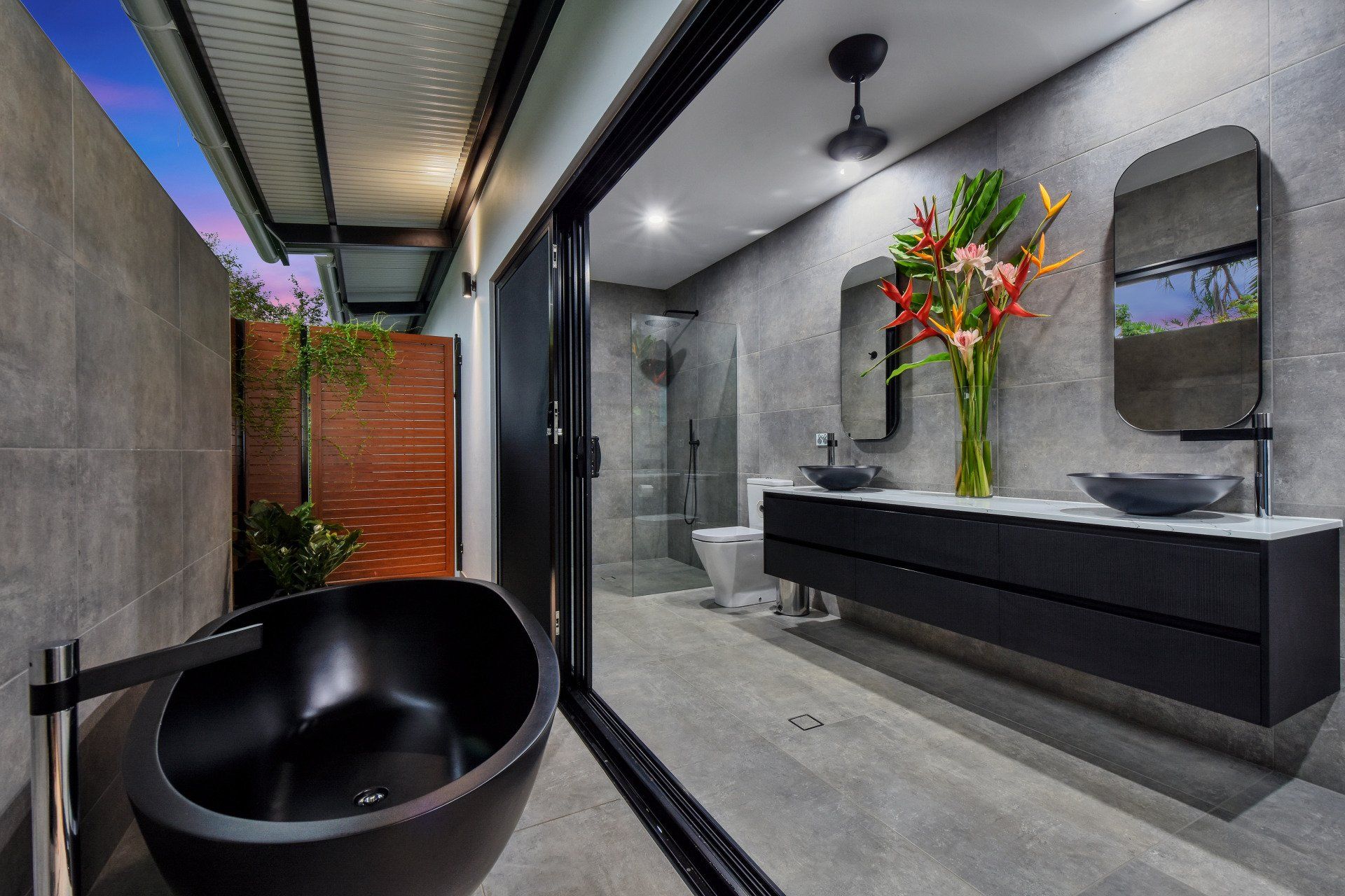 A bathroom with a black bathtub and two sinks