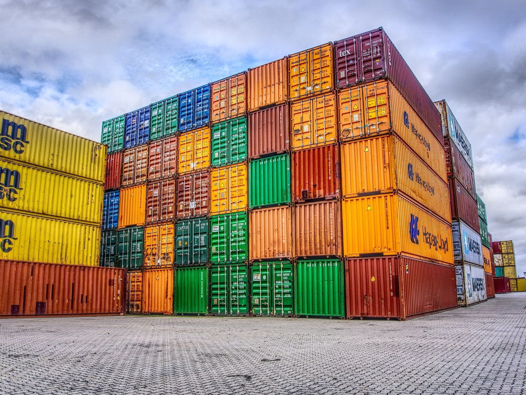 a large stack of colorful shipping containers are stacked on top of each other .