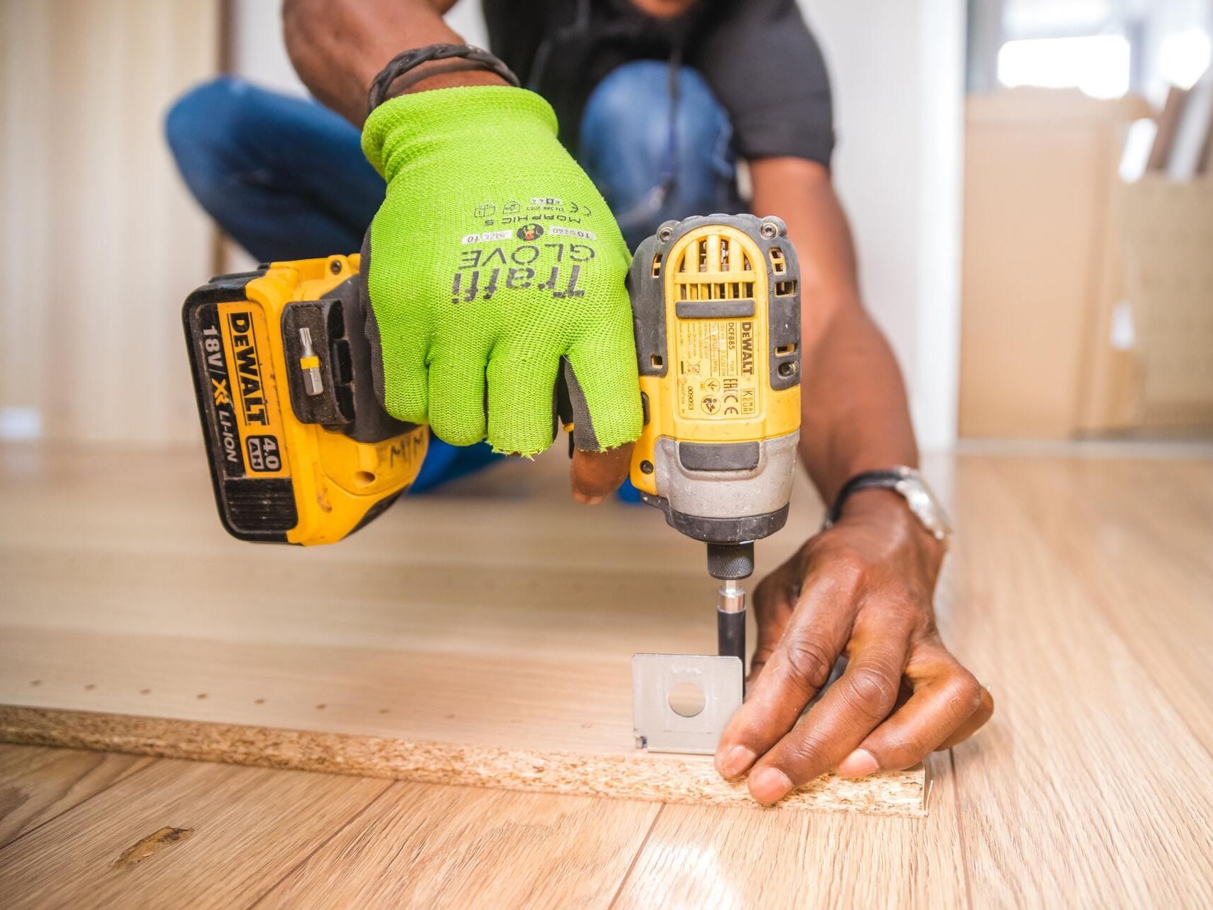 a man is using a drill on a piece of wood .