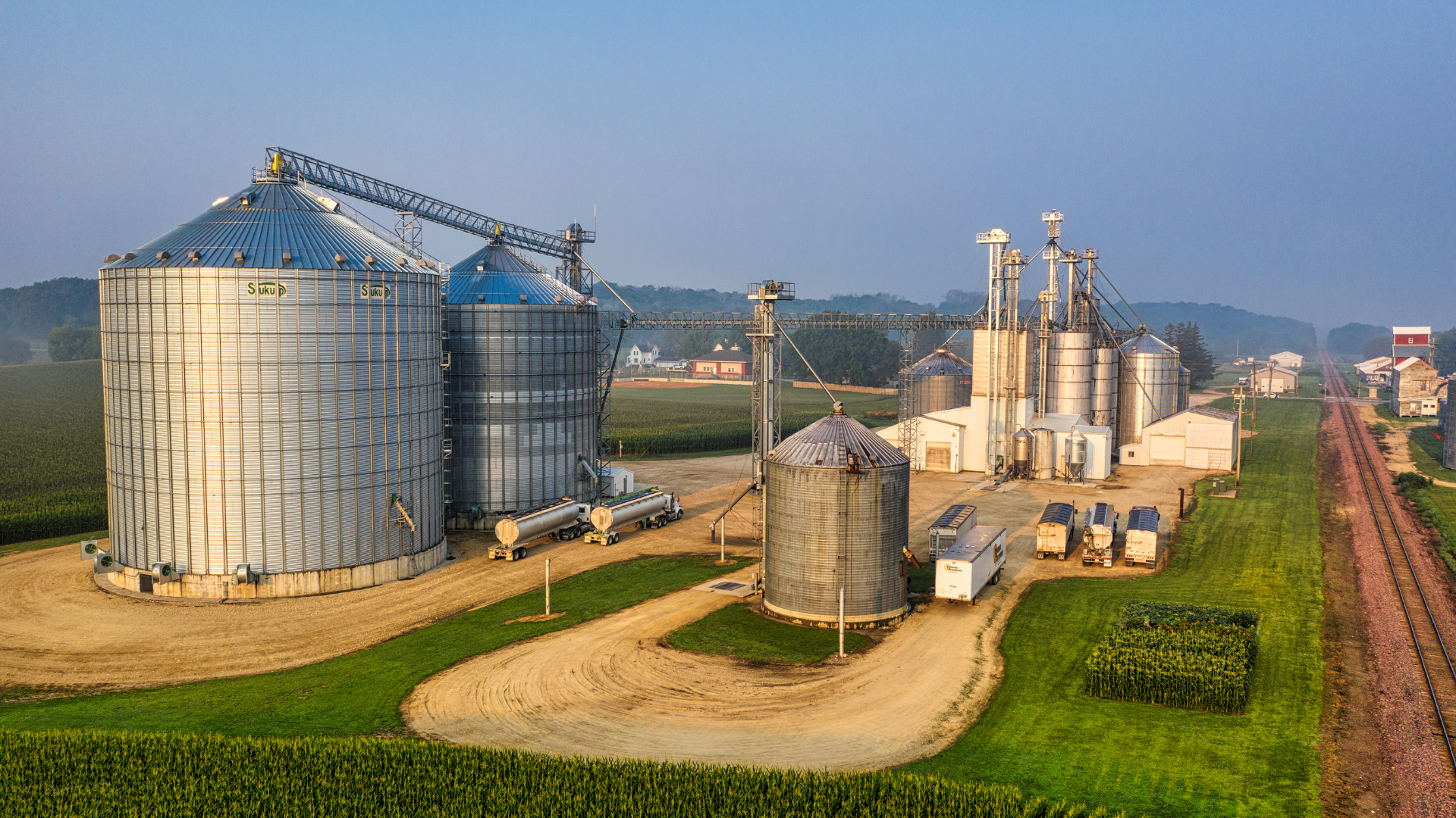 Silos de granos y planta procesadora en entorno rural.
