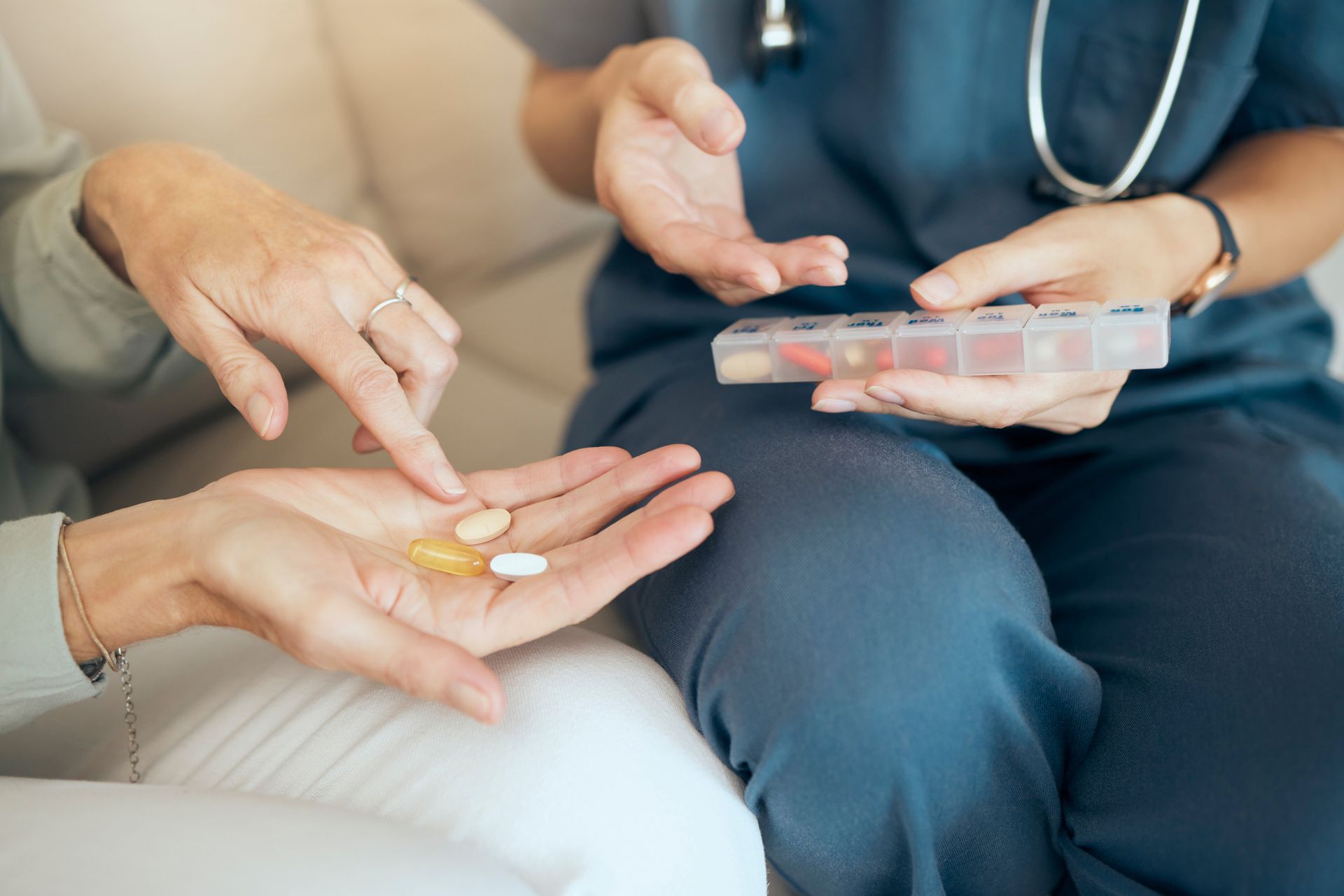 Person receiving pills from a healthcare worker, illustrating medication guidance.