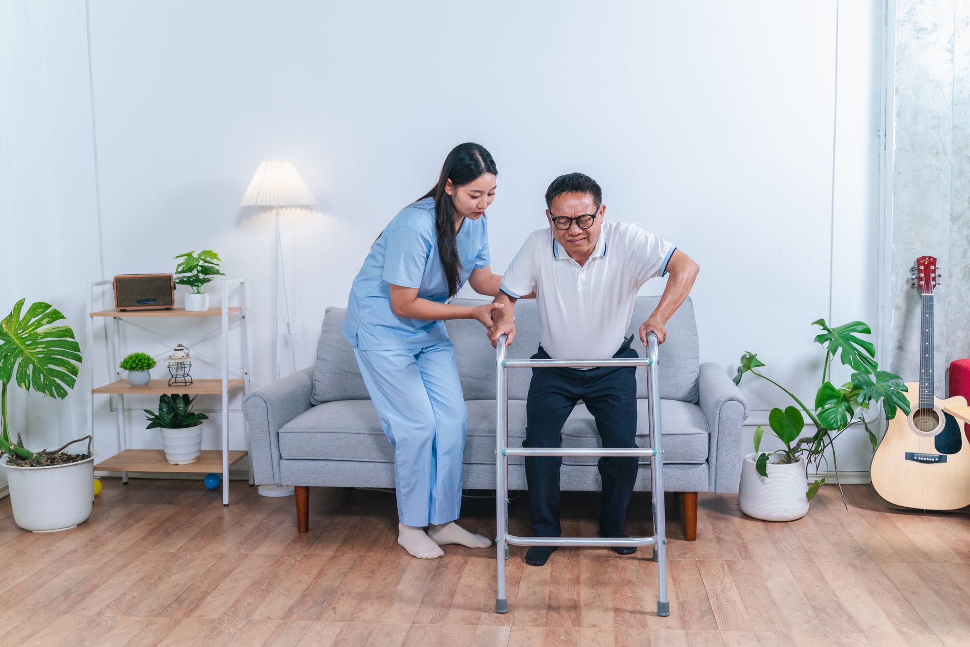 Caregiver assisting a person using a walker in a living room.