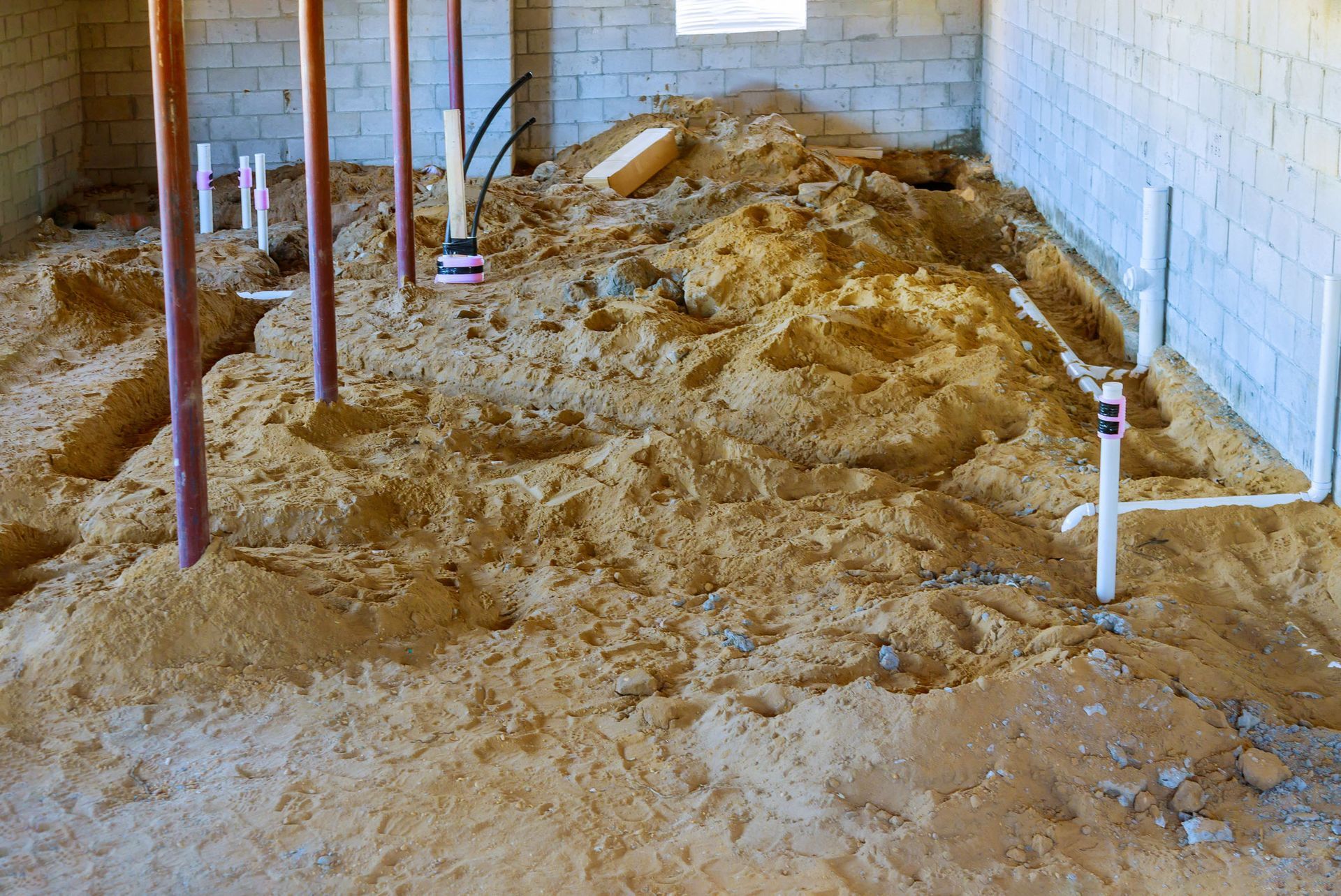 A room with a lot of sand and pipes in it.