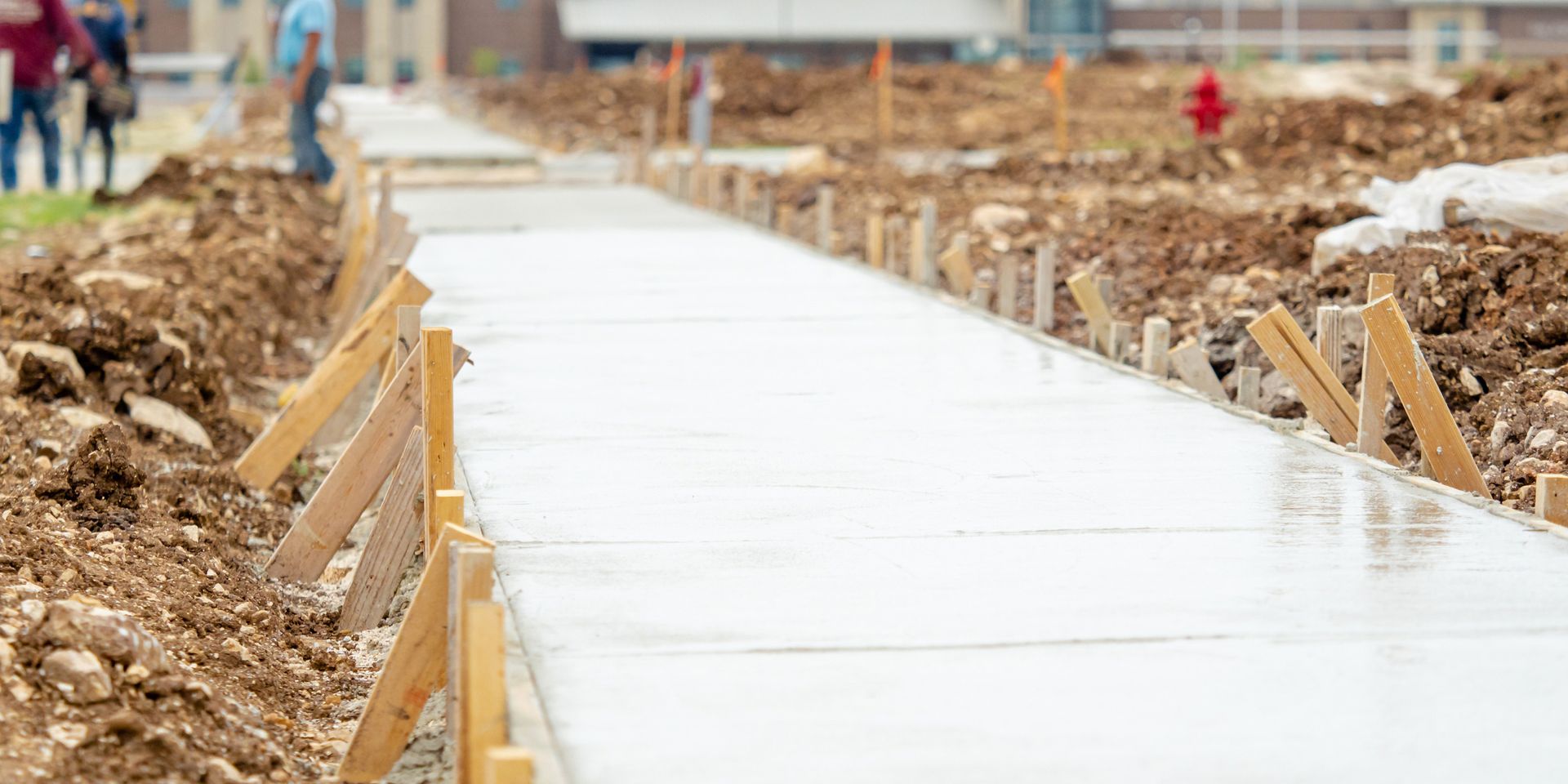 A concrete walkway is being built on a construction site.