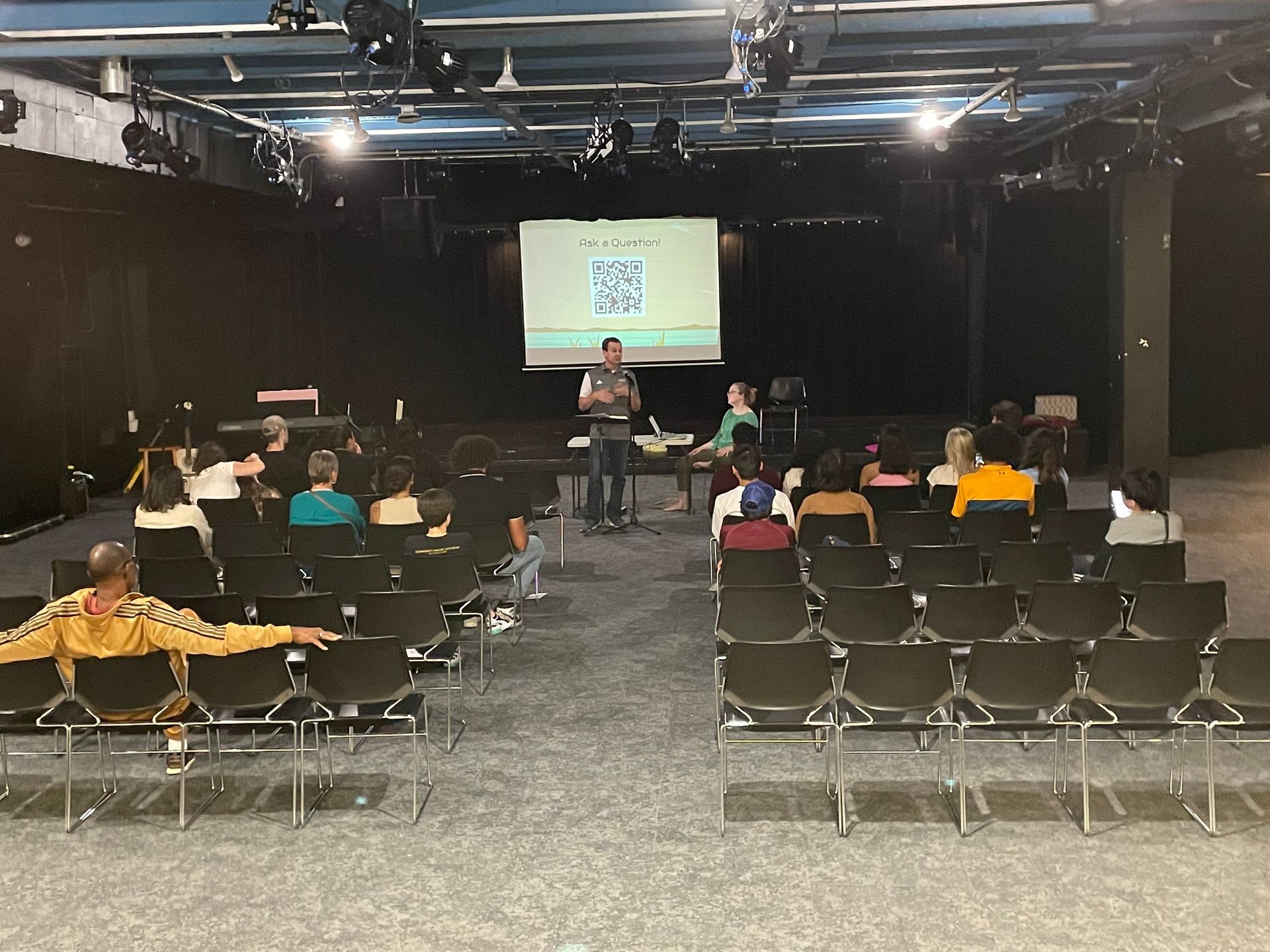 A man is giving a presentation to a group of people in an auditorium