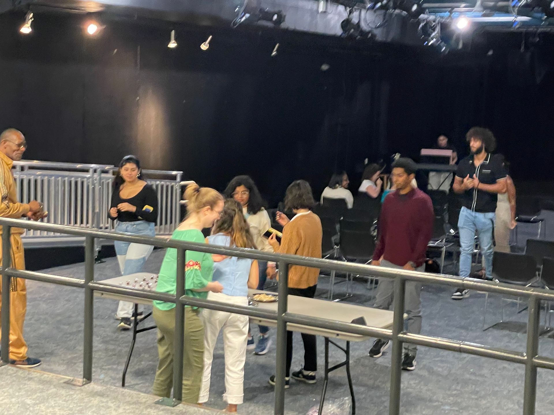 A group of people are standing around a table in a dark room.