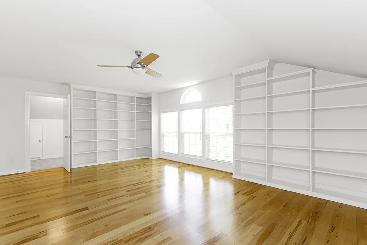 Birch flooring in an empty spacious apartment with white walls.