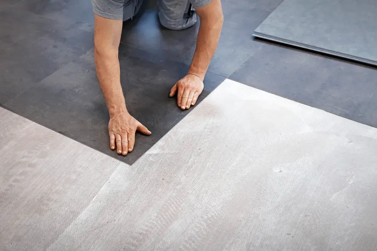 Man installing a cheap flooring option, vinyl sheet.