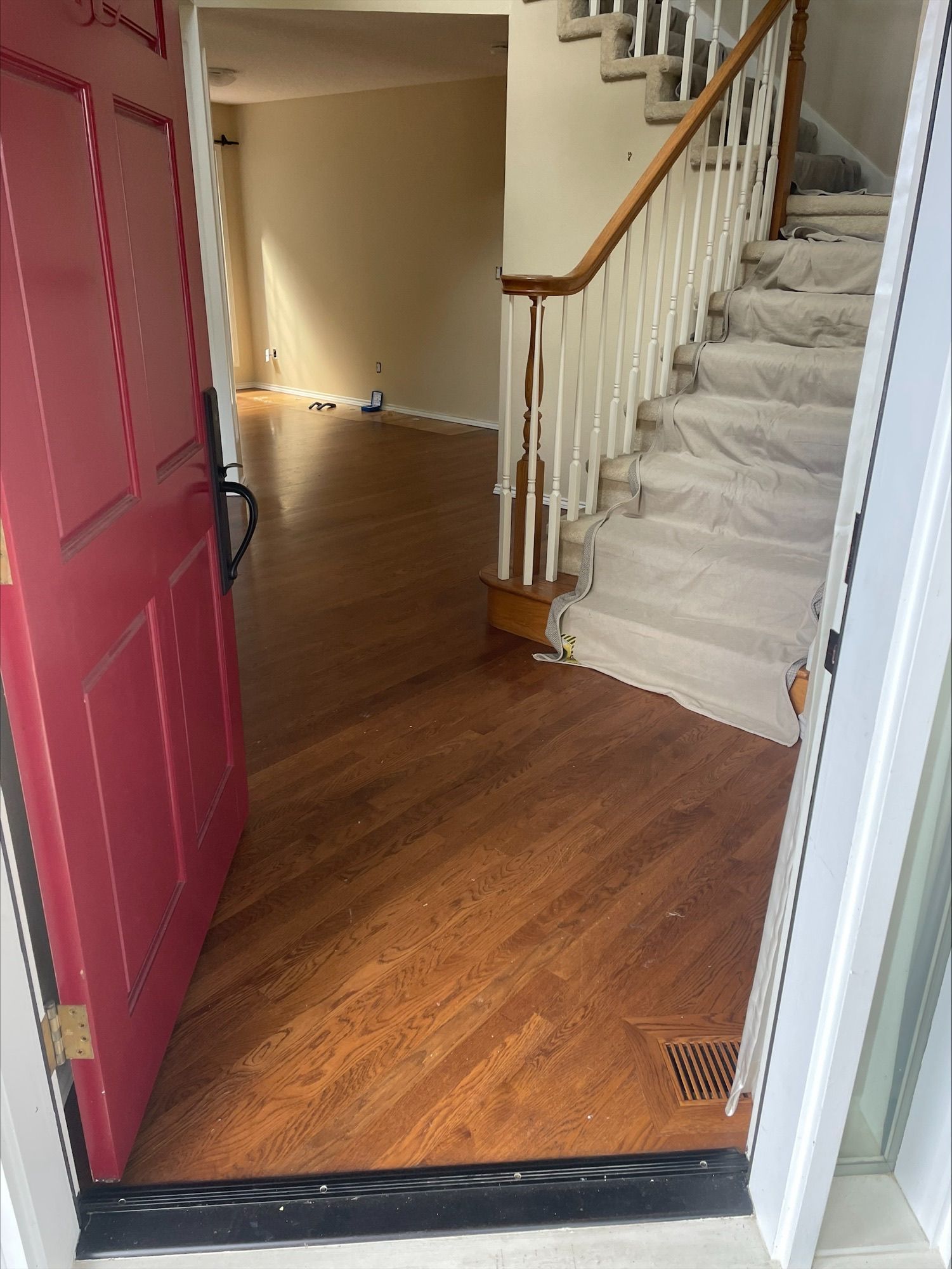 Open door leading to a room with older hardwood flooring.