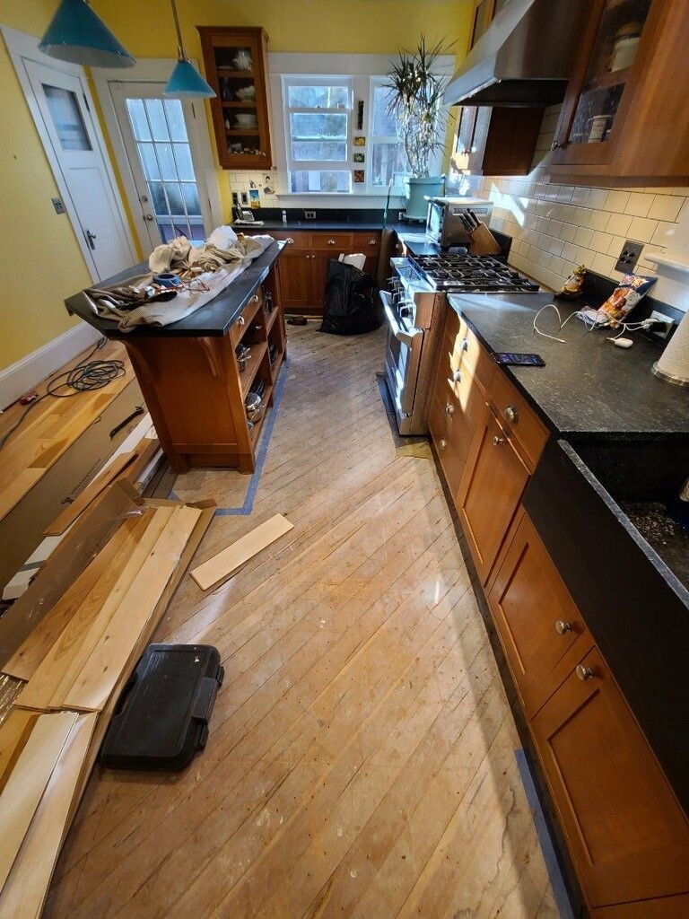 Messy kitchen before flooring replacement.