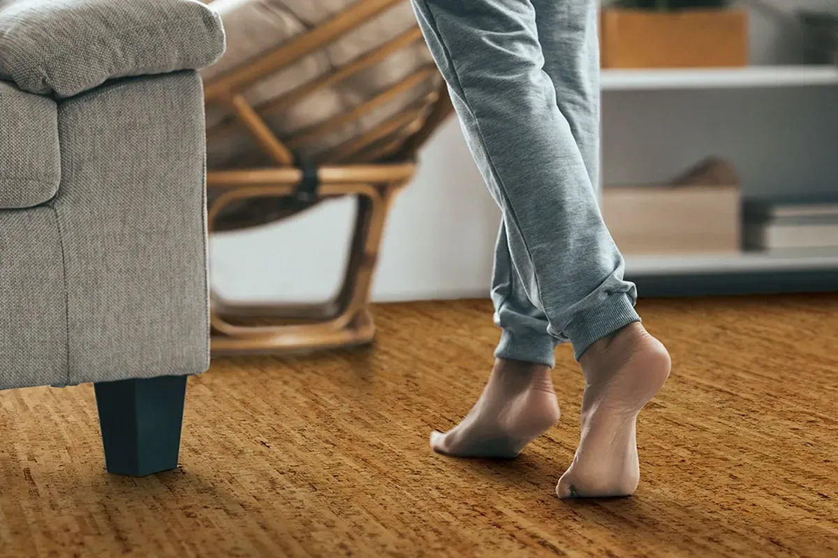 Person walking barefoot over cork flooring.