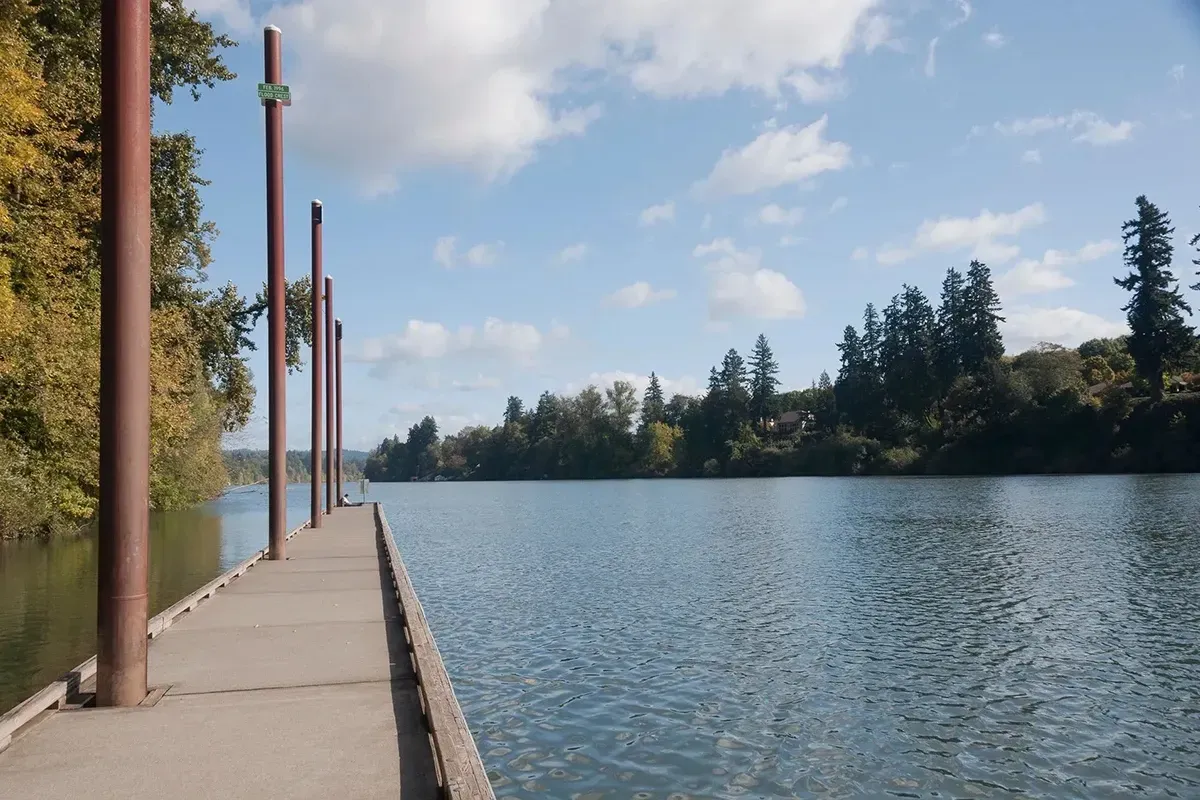 A dock overlooking a lake with trees in the background in Wilsonville, Oregon.