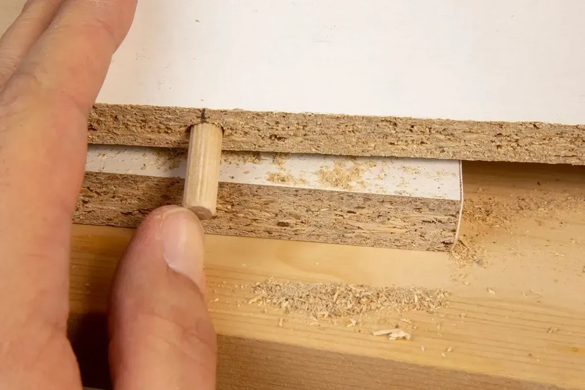 Inserting a spline into a wood floor plank.