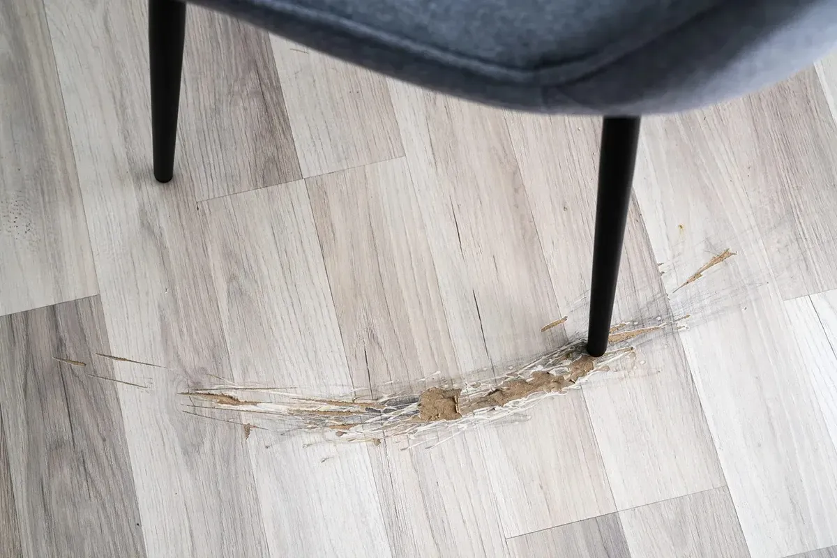 Badly scratched vinyl plank flooring.