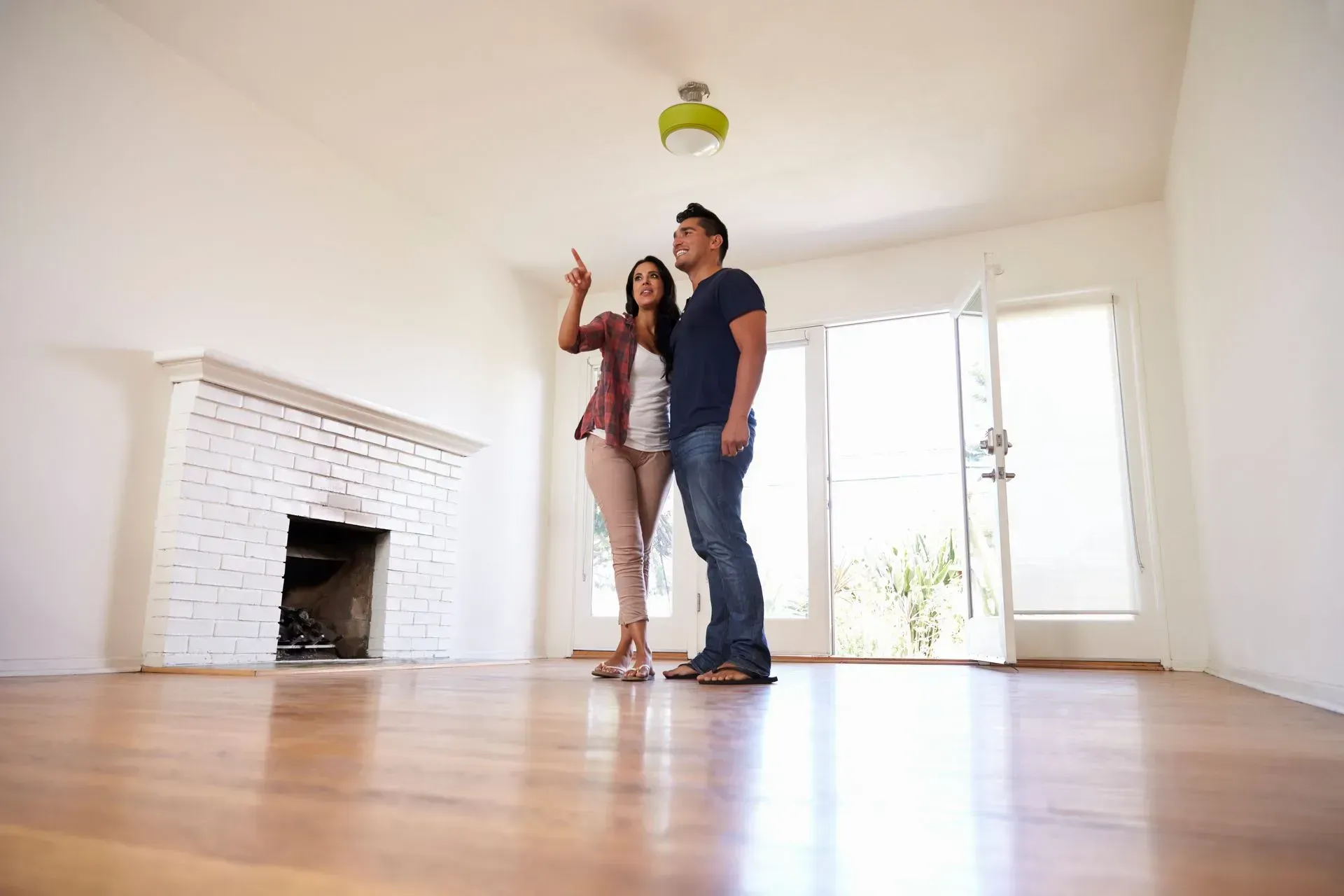 Young couple considering buying a home with hardwood floors.