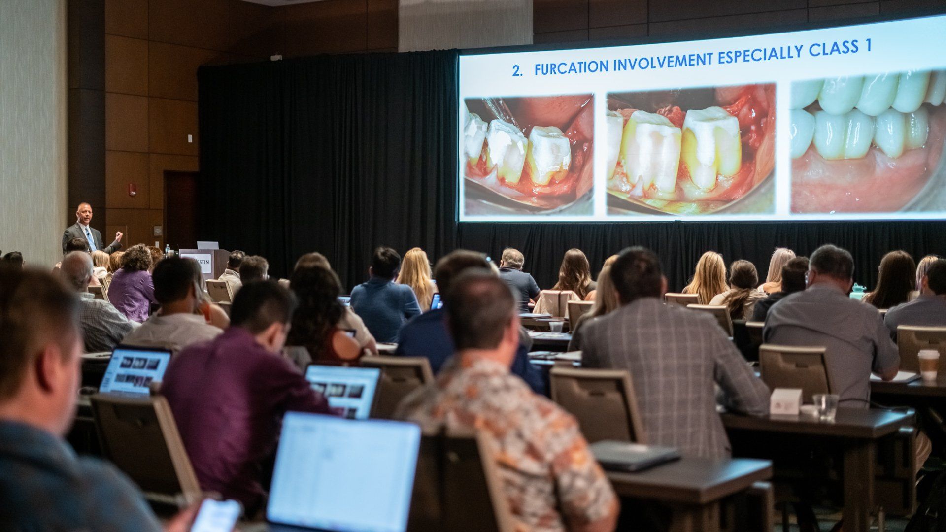 A group of people are sitting in a classroom watching a presentation.