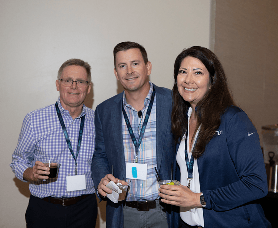A group of people are posing for a picture while holding drinks.