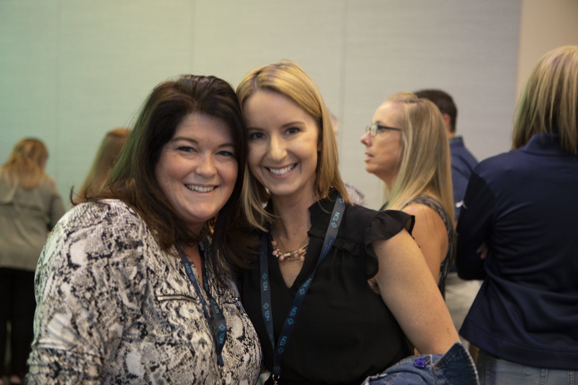 Two women are posing for a picture together in a room.