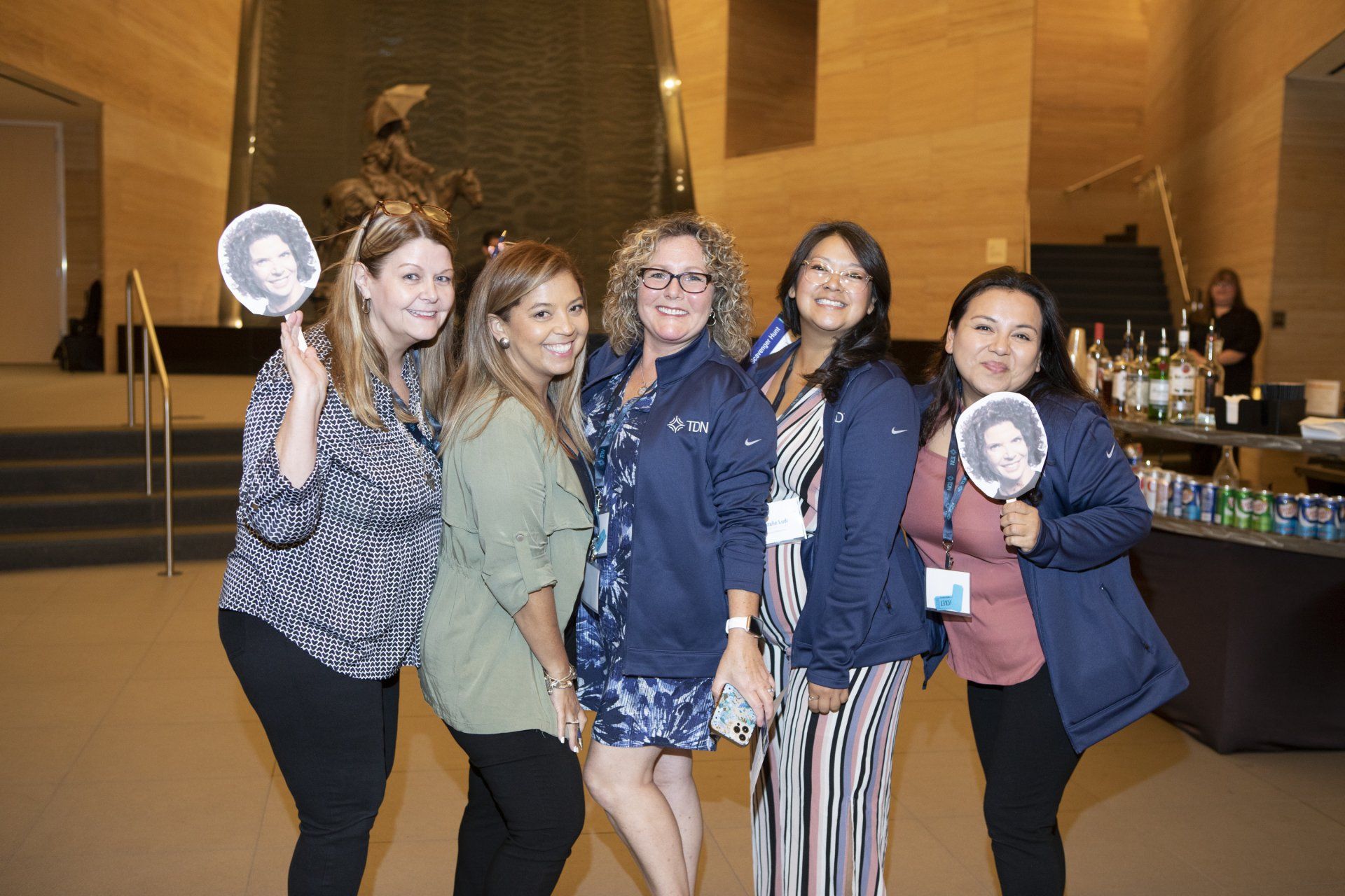 A group of women are posing for a picture in a room.