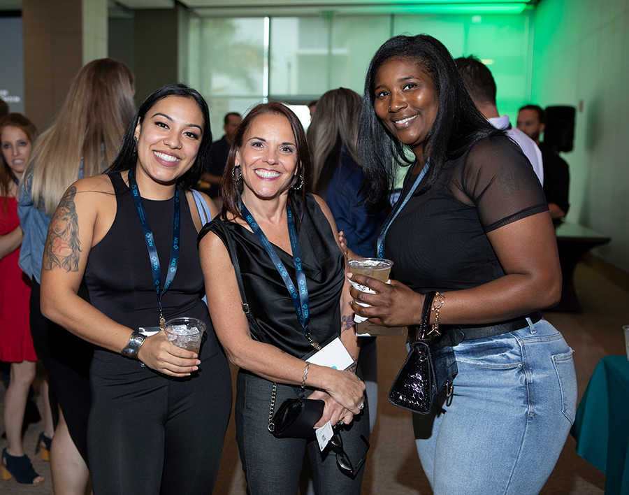 Three women are posing for a picture at a party.