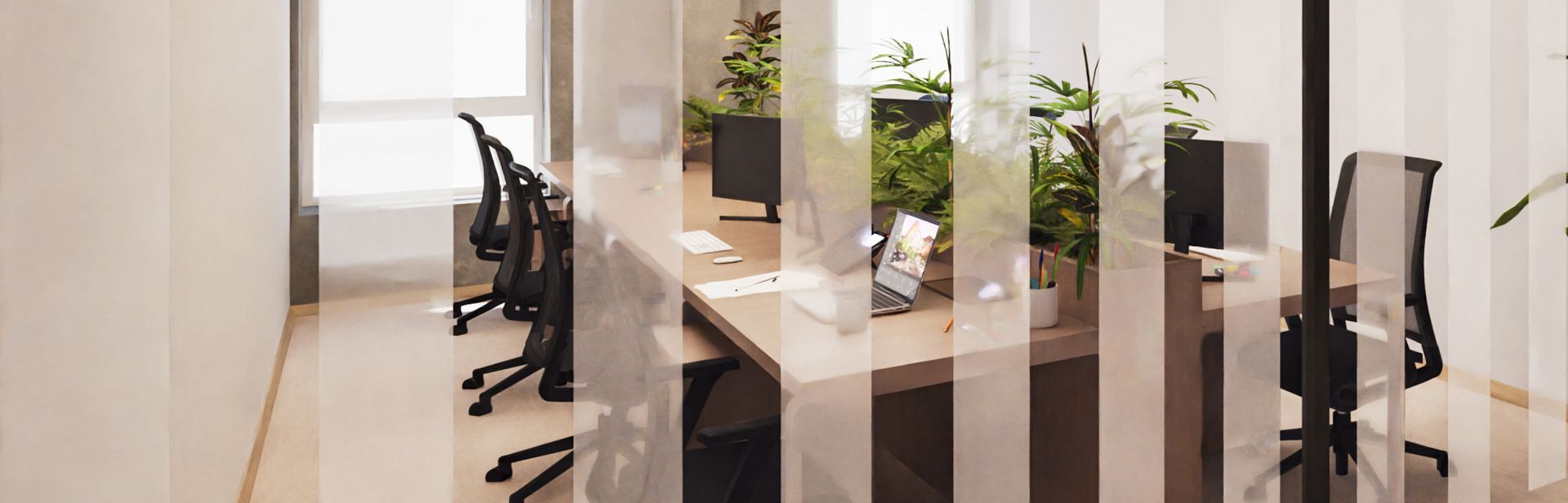Office workspace with desks, chairs, computers, and plants behind a translucent striped barrier.