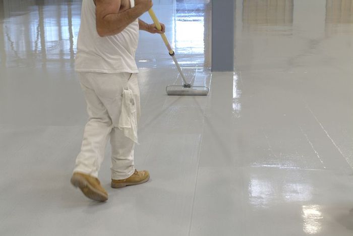 A man is cleaning the floor with a mop.