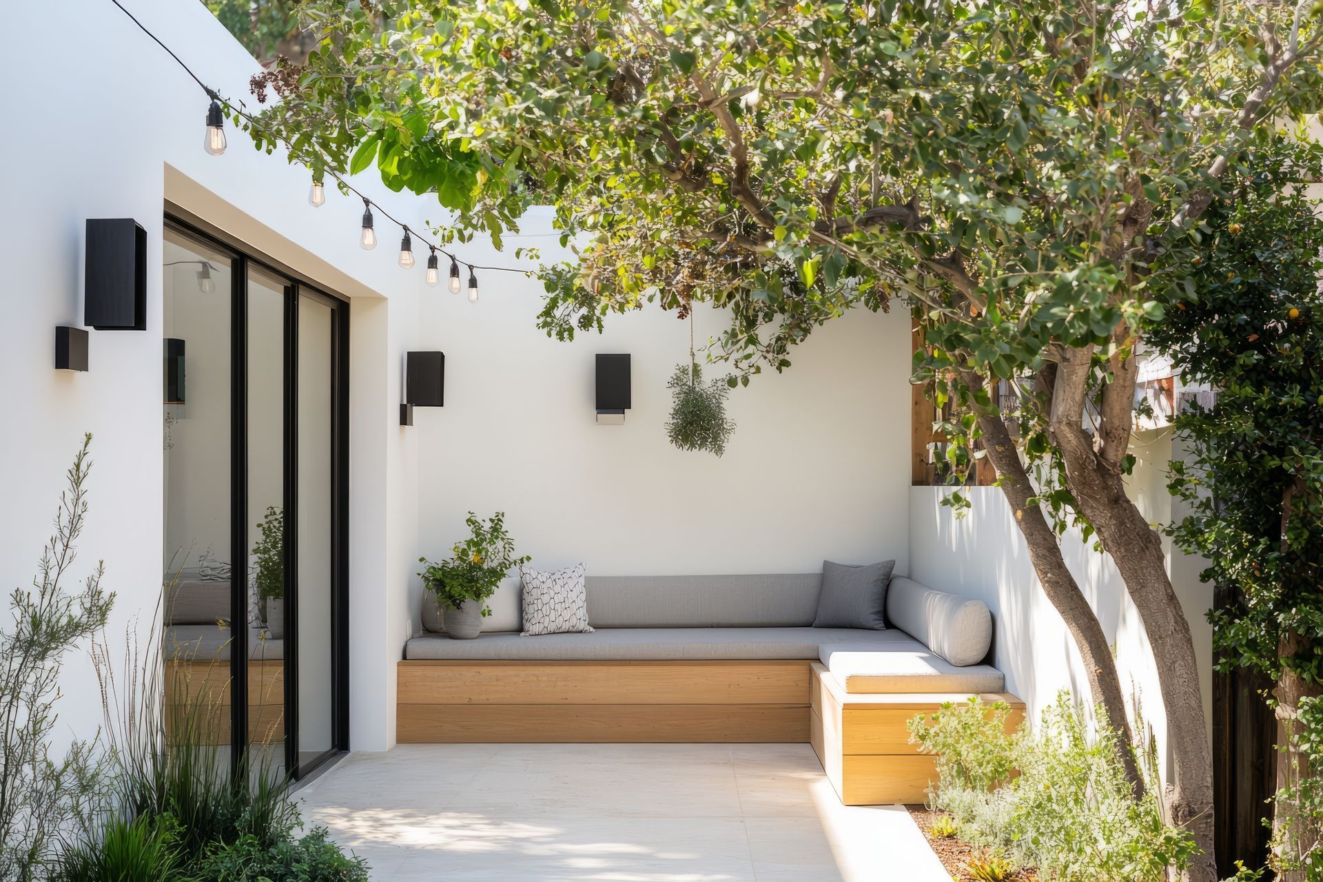 A patio with a table and chairs in the backyard of a house.