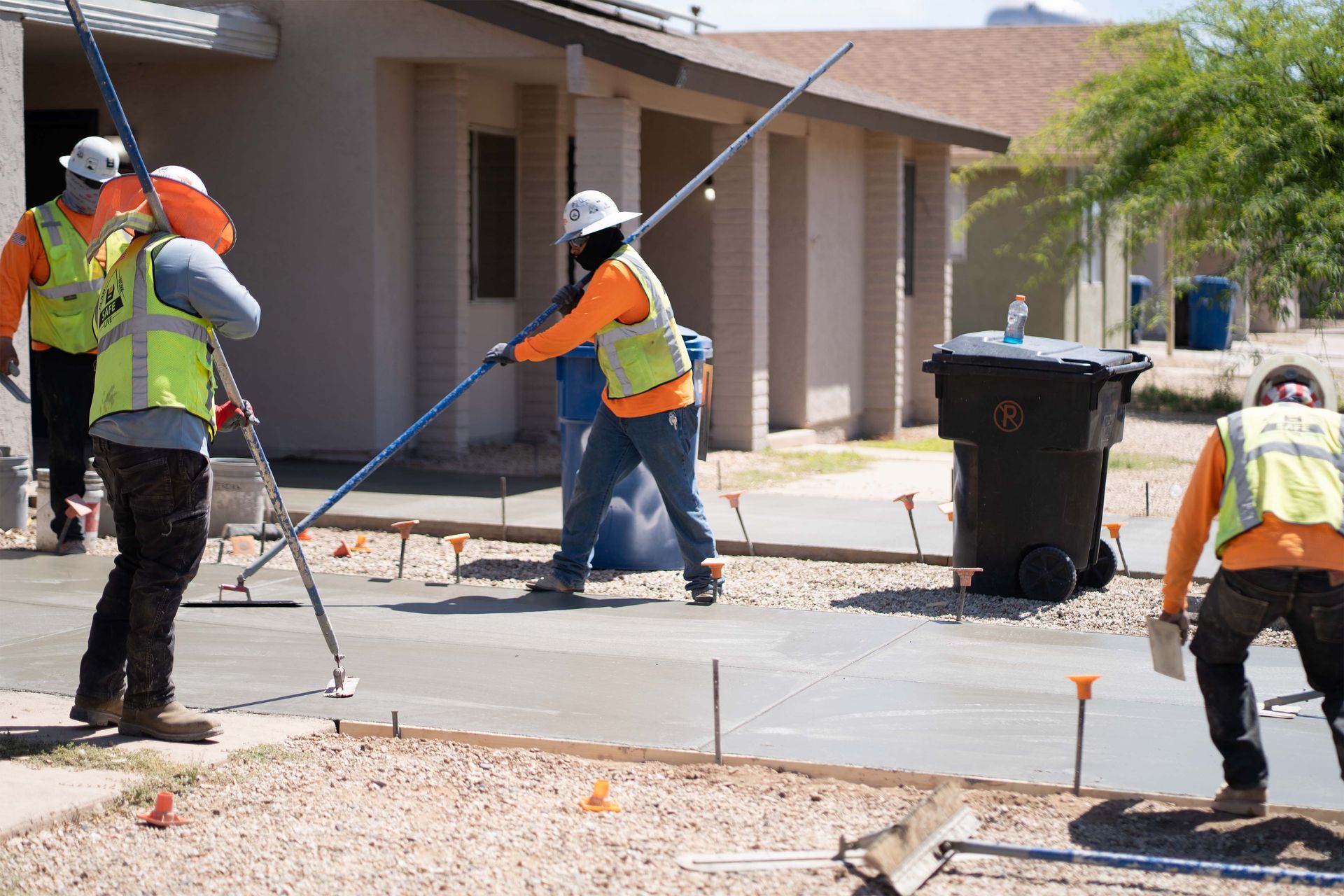 A red car is parked in front of a modern house.
