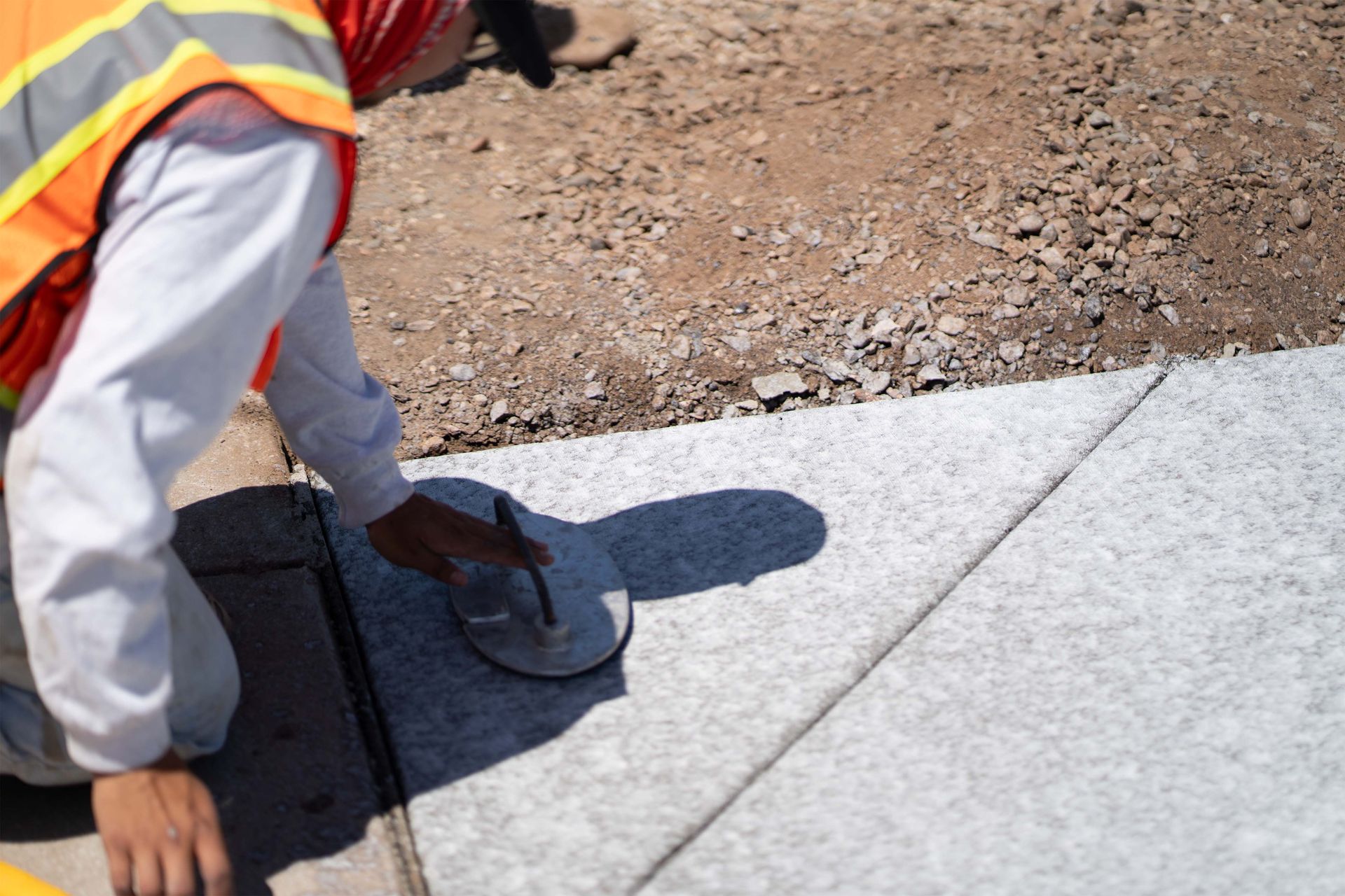 A brick driveway leading to a house with a lush green lawn.