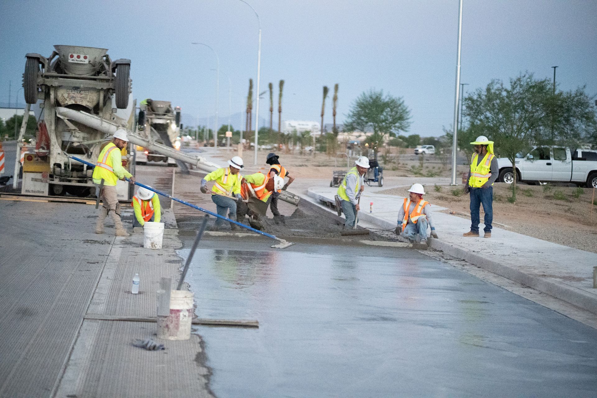 A concrete pump is being used to pour concrete on a construction site with mountains in the background.