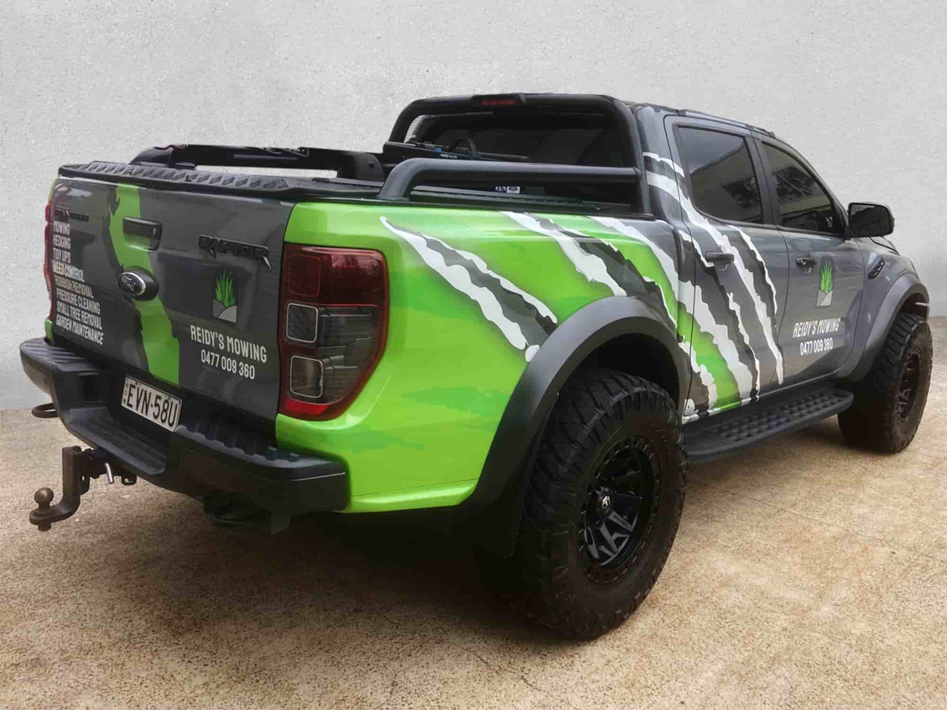 A Green And Black Truck Is Parked On The Side Of The Road — Solis Signs in Toukley, NSW