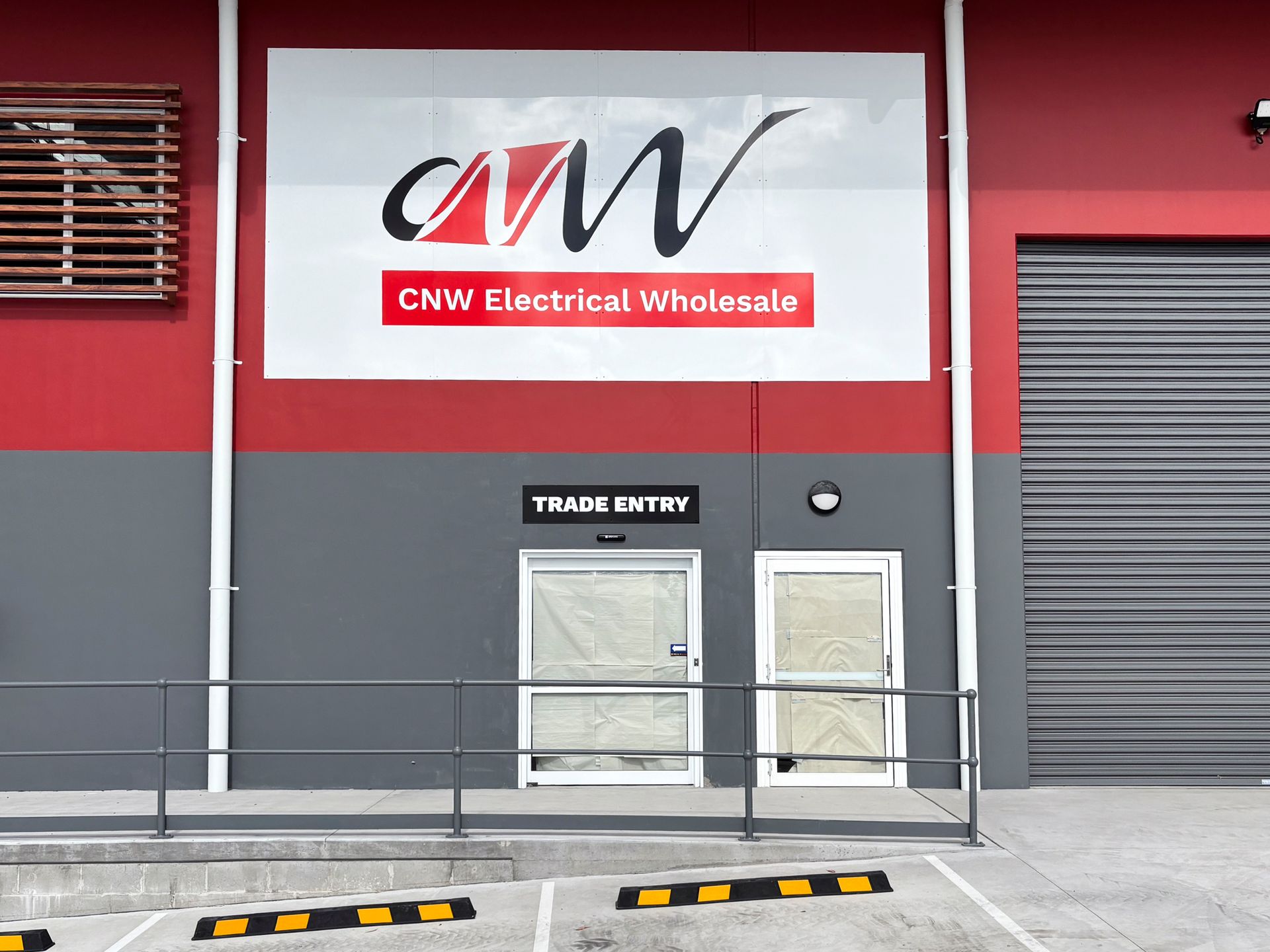 Cnv electrical wholesale has a large sign on the side of their building— Solis Signs in Toukley, NSW