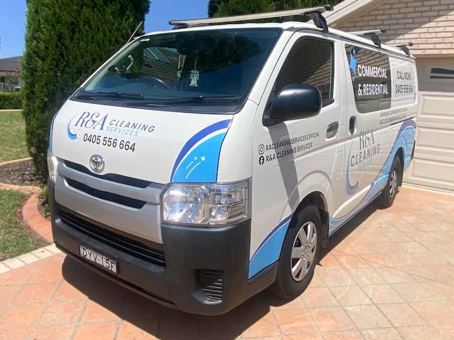 A White And Blue Van Is Parked In Front Of A House — Solis Signs in Toukley, NSW