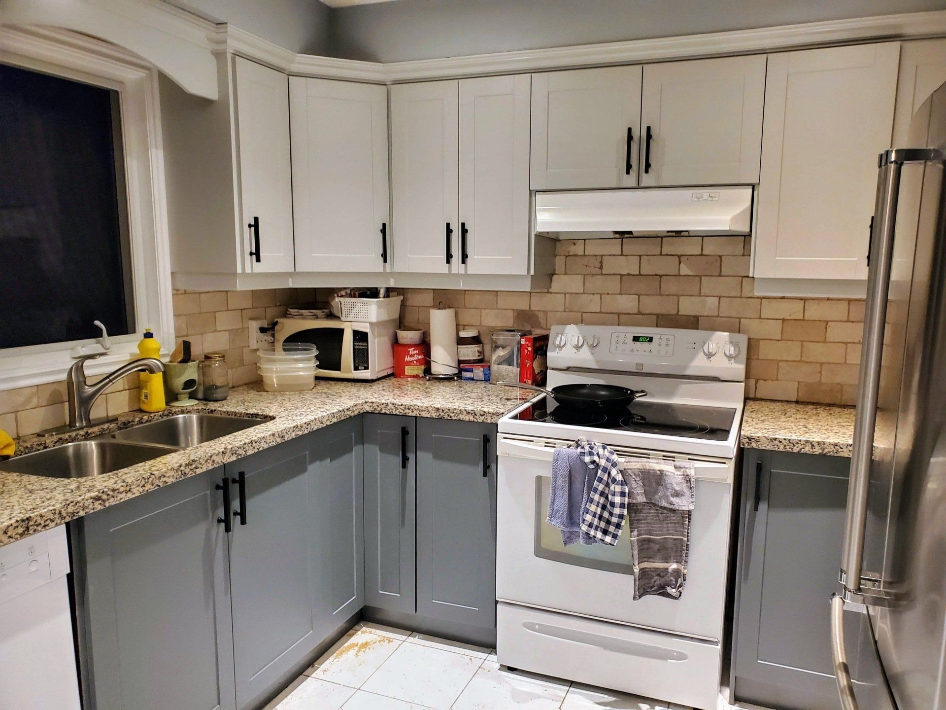 A kitchen with a stove , sink , and refrigerator