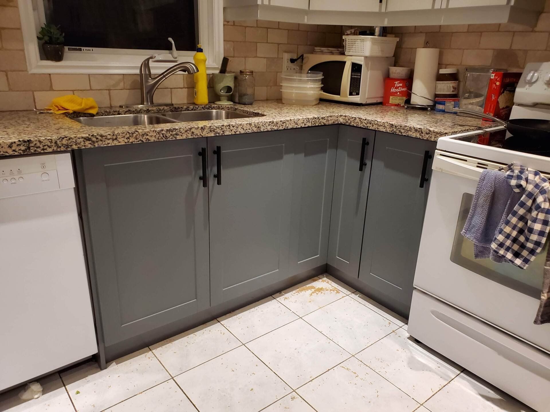 A kitchen with gray cabinets and a white stove