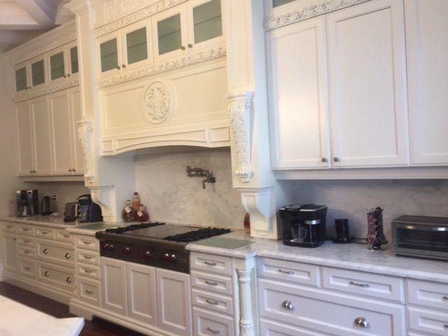 A kitchen with white cabinets and a stove top oven