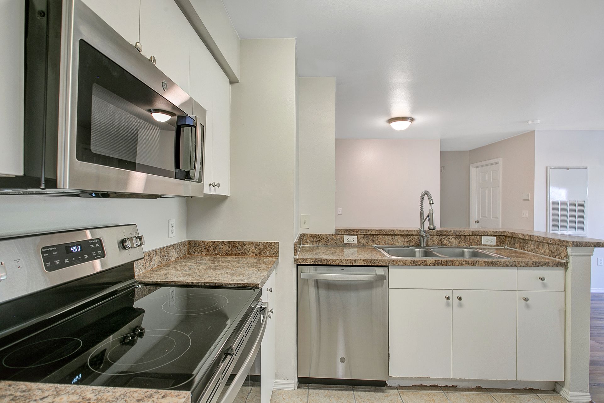 A kitchen with stainless steel appliances and granite counter tops.