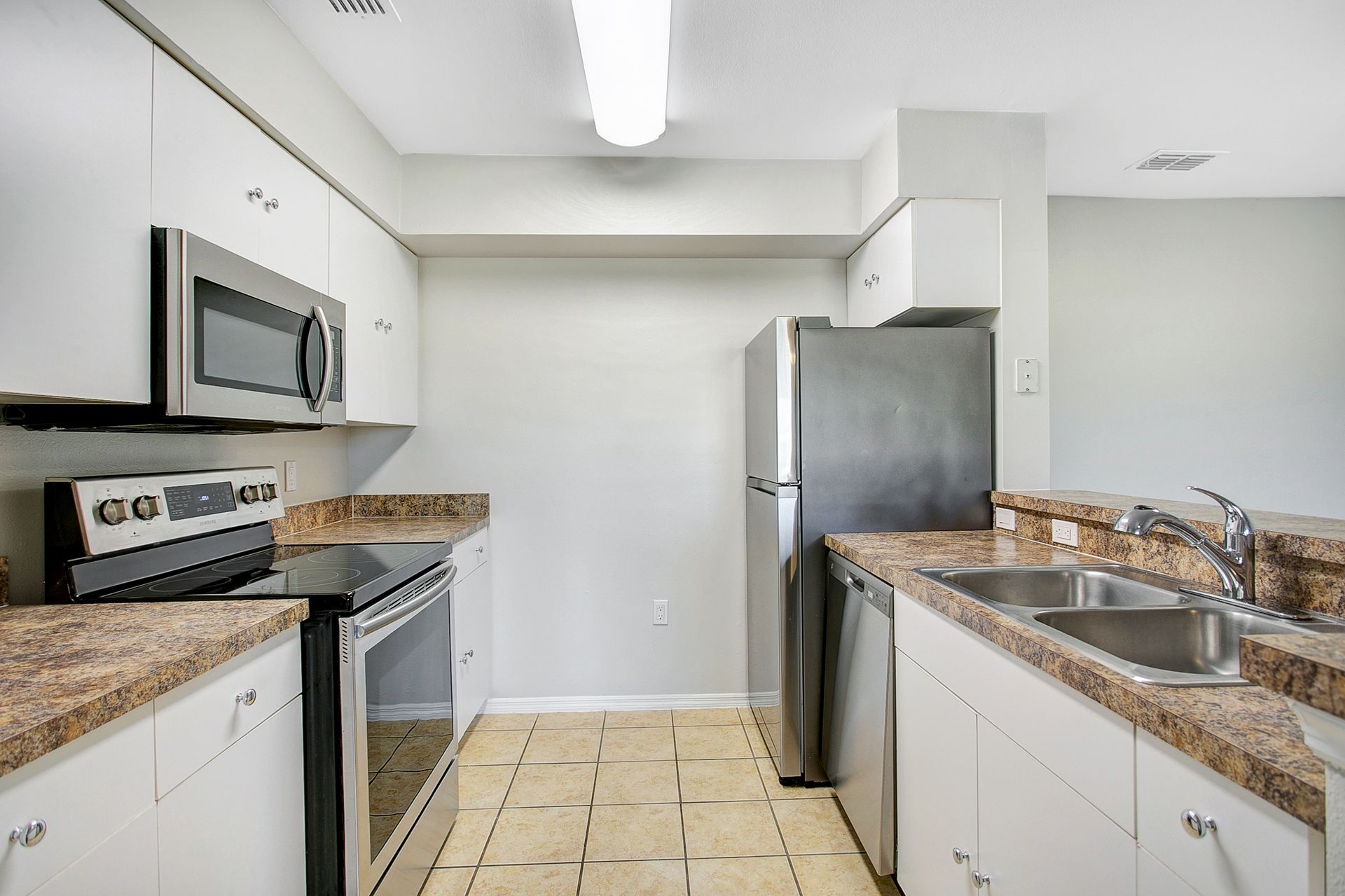 A kitchen with stainless steel appliances and granite counter tops.