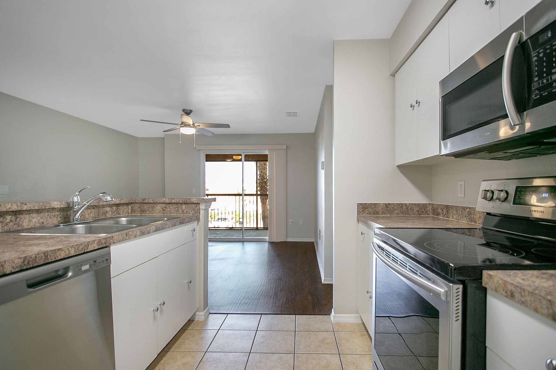 A kitchen with a stove , microwave , sink , and dishwasher.