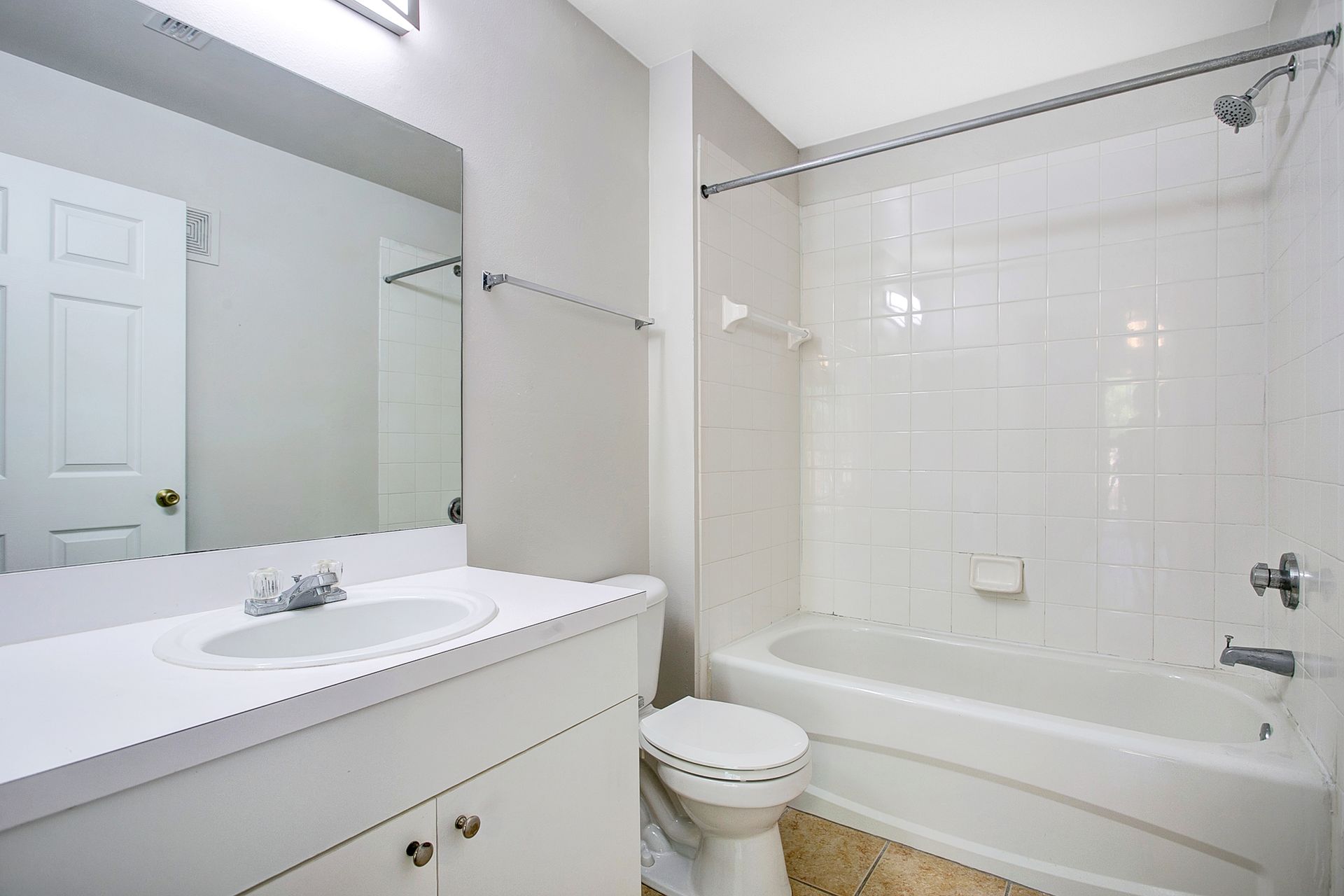 A bathroom with a sink , toilet , bathtub and mirror.