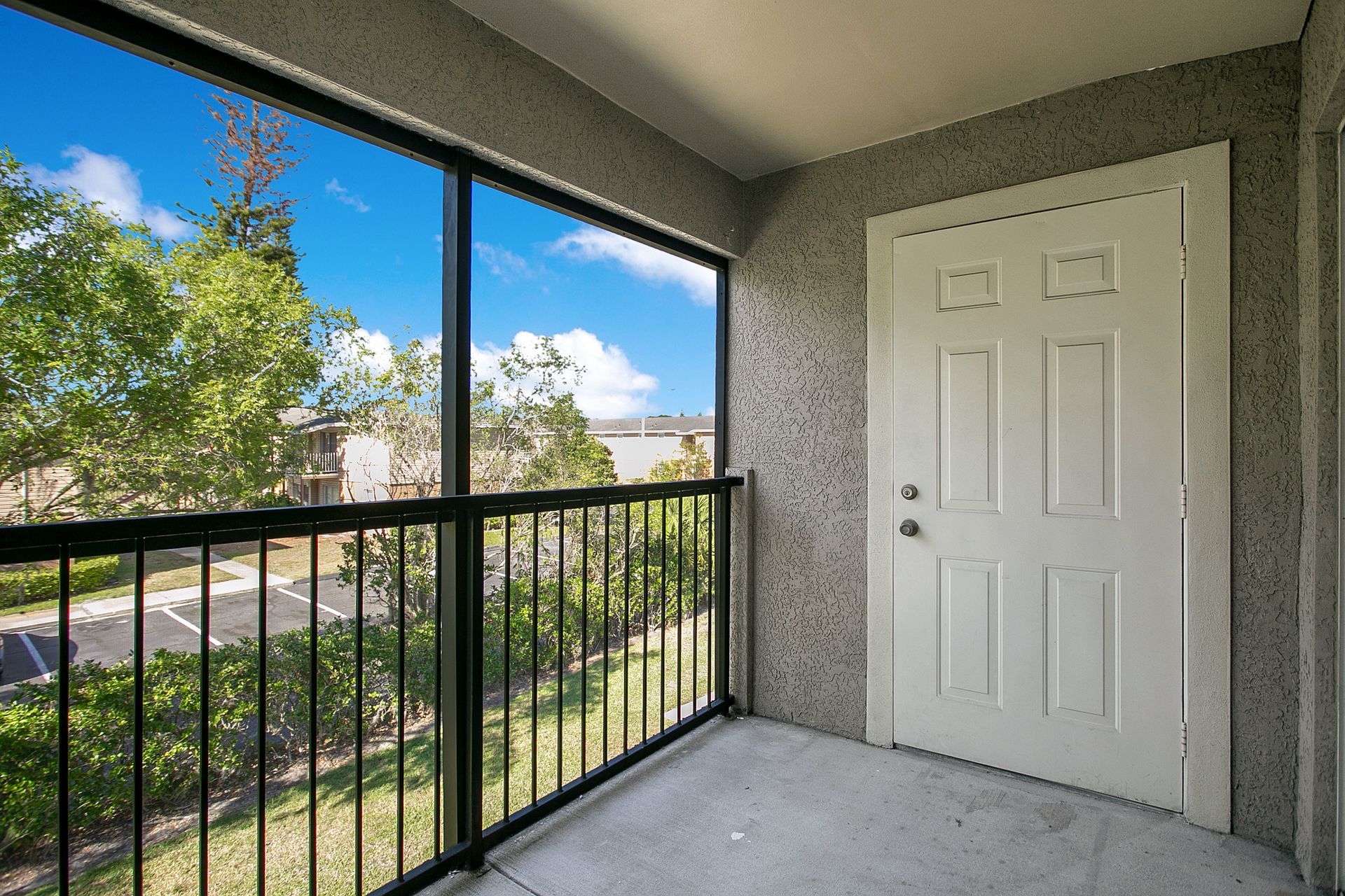 A balcony with a white door and a black railing.