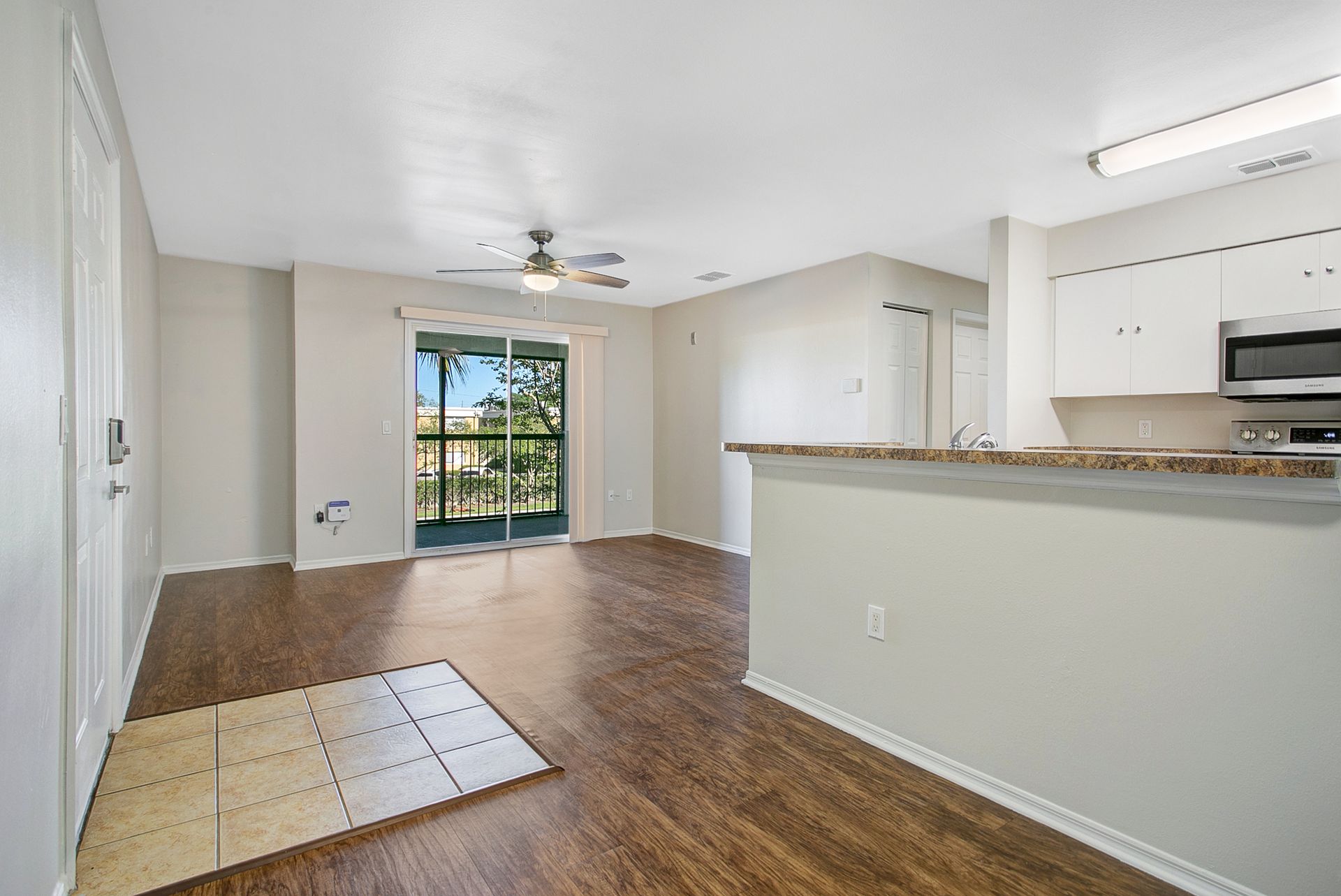 A living room with hardwood floors and a ceiling fan.