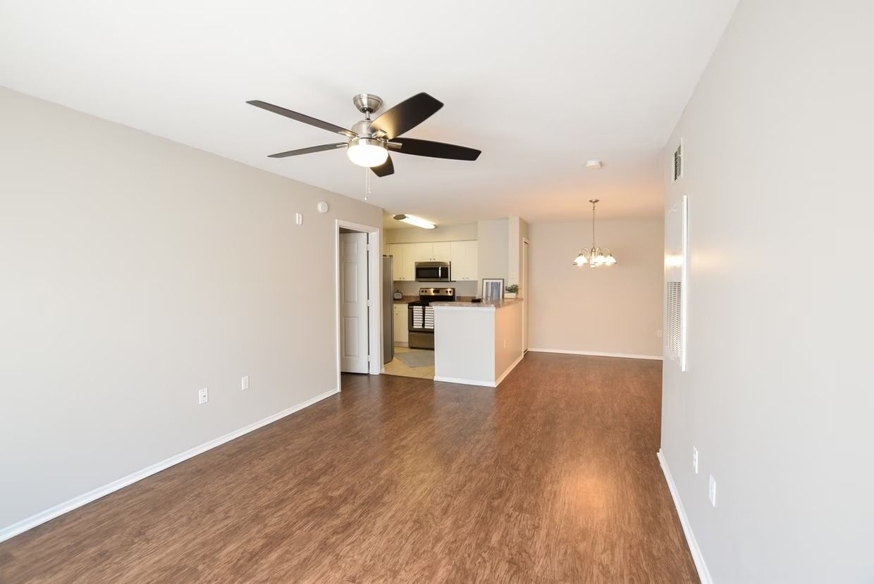 A living room with hardwood floors and a ceiling fan.