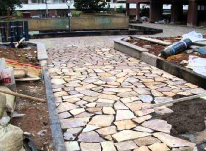 Posa di piastrelle di pietra in un giardino