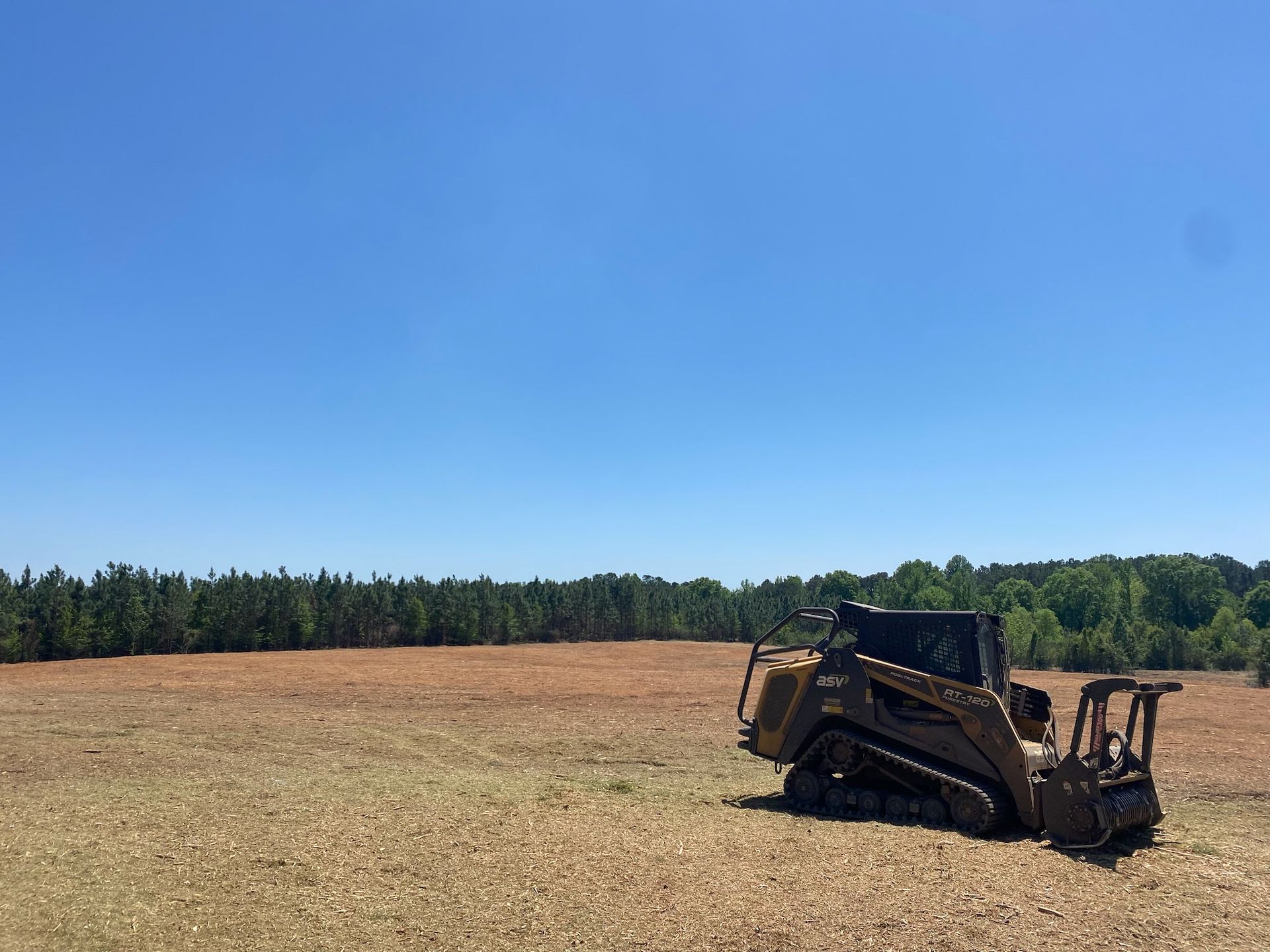 A bulldozer is sitting in the middle of a field.