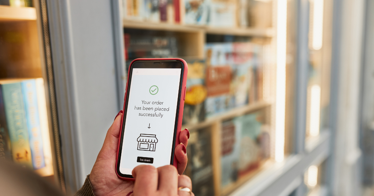 Person holding phone with order confirmation screen, illustrating actionable buying behavior in mobile shopping.