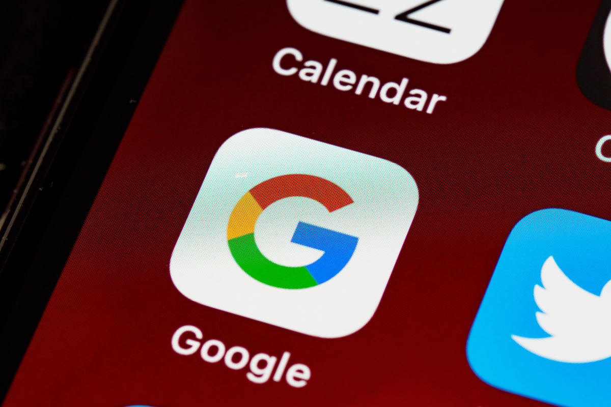 Close-up of the Google app icon on a smartphone screen, highlighting digital tools for managing online listings.
