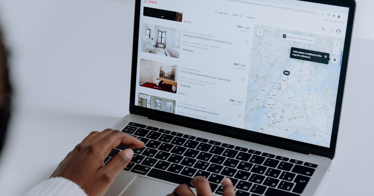 User browsing real estate websites on a laptop, viewing property listings and map locations for rentals in New York.