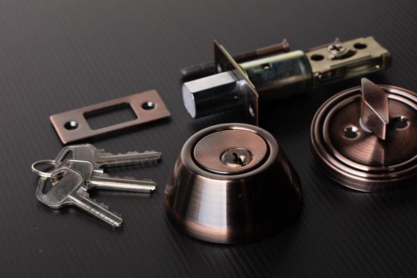 A close up of a door lock with keys on a table.